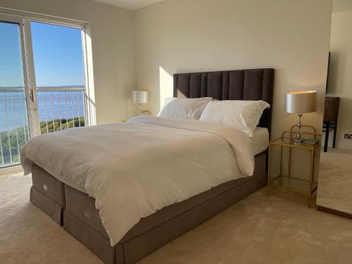 a bedroom with a large bed with a large window at Home in Portishead