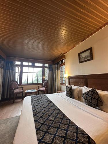 1 dormitorio con 1 cama grande en una habitación en Wingait Inn - Hotel Near The Mall Road, en Shimla