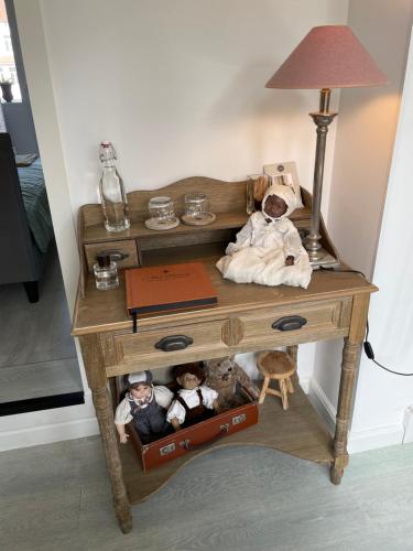 a wooden table with stuffed animals and a lamp on it at B&B Villa Navy in Koksijde