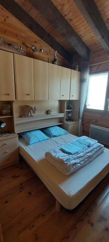 uma cama grande num quarto com pisos em madeira em Logement cosy au pied des pistes em Saint-Pierre-dels-Forcats