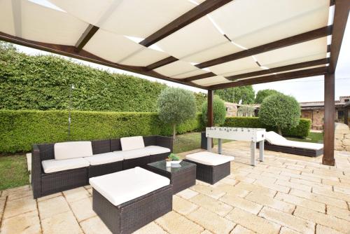 a patio with a black and white couch and a table at Mythos Holidays & Events in Siracusa