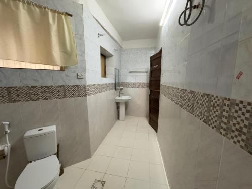 een badkamer met een toilet en een wastafel bij Mokawa BnB Stone Town in Ngambo