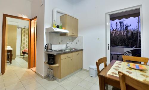 a kitchen with a table and a dining room at Paleochora Elizabeth Apartments in Palaiochóra