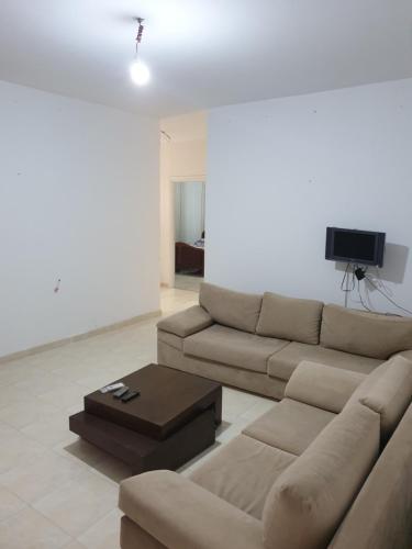 salon z kanapą i telewizorem w obiekcie Appart privé w mieście Soliman