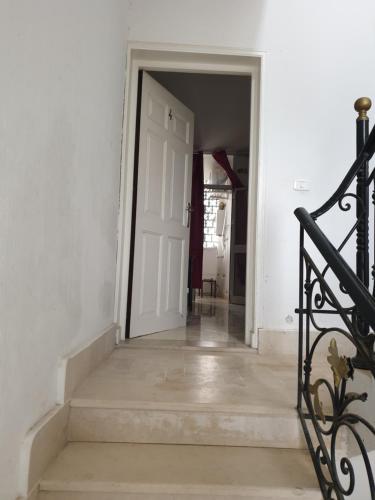 an empty hallway with a white door and stairs at Appart privé in Soliman