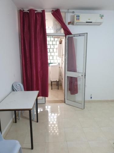 Pokój z czerwoną zasłoną i przesuwnymi szklanymi drzwiami w obiekcie Appart privé w mieście Soliman