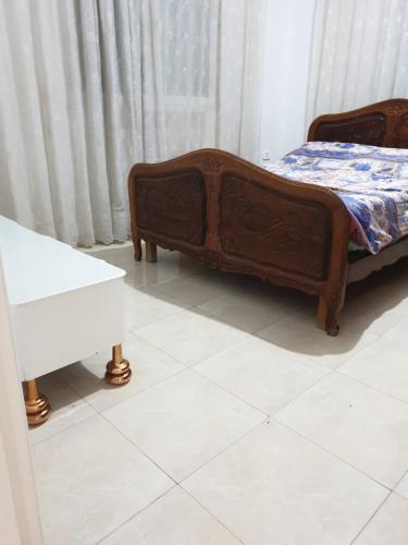 a bedroom with a bed and a white tile floor at Appart privé in Soliman