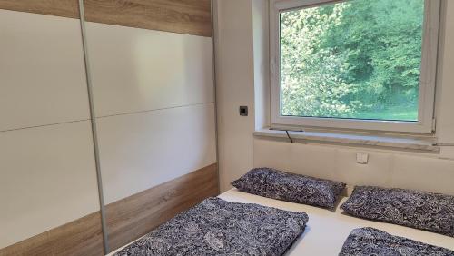 Habitación con 2 almohadas y ventana en Moderne-Ferienwohnung-nur-1km-vom-Millstaetter-See-in-Kaernten-entfernt, en Millstatt