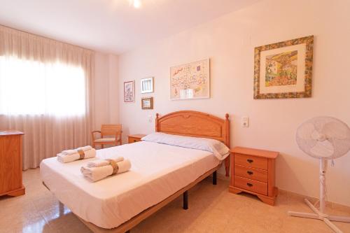 a bedroom with a bed and a fan at Global Properties, Apartamento con terraza de 70m y piscina en Canet de Berenguer in Canet de Berenguer