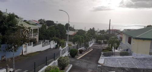 an aerial view of a street with a white fence at Le p'tit nid cocodydy in Baillif