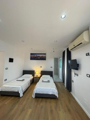 a room with two beds and a television in it at House Pollo in Ksamil