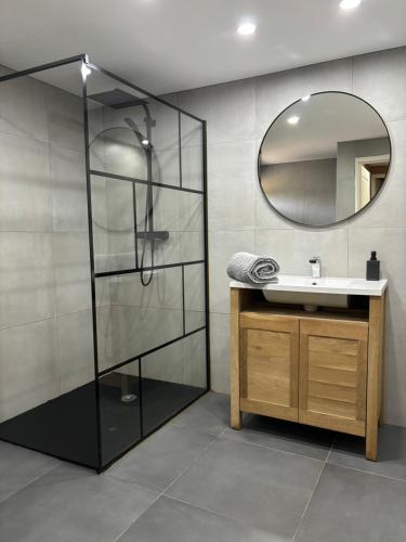 uma casa de banho com um lavatório e um espelho em Chalets du Bouchot & Jacuzzi privatif proximité Gerardmer & La Bresse em Rochesson