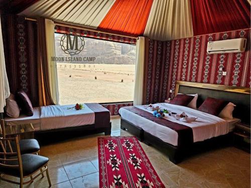 sypialnia z 2 łóżkami i oknem z plażą w obiekcie Moon Island Camp w mieście Wadi Rum