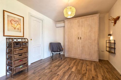 a room with a wooden cabinet and a chair at Sa Domo Isola Rossa in Trinità dʼAgultu