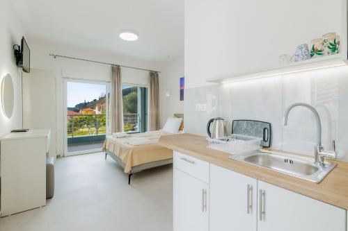 a kitchen with a sink and a bed in a room at Chloe Studios in Parga