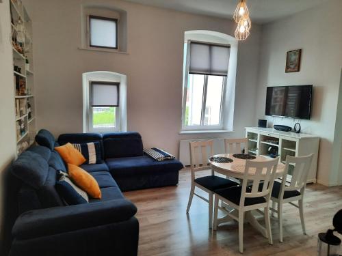 una sala de estar con un sofá y una mesa en Apartament Przy Marinie, en Giżycko