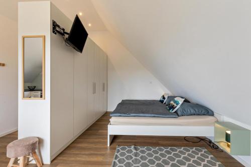 een slaapkamer met een bed en een tv aan de muur bij Bergstüble Schwabenglück in Günzburg