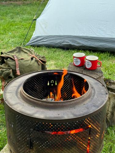 a fire pit with two coffee cups and a tent at Sport Hostel Cluj in Cluj-Napoca