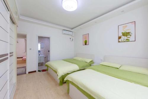 Dos camas en una habitación con paredes blancas. en Xi Valley Apartment, en Zhangjiajie