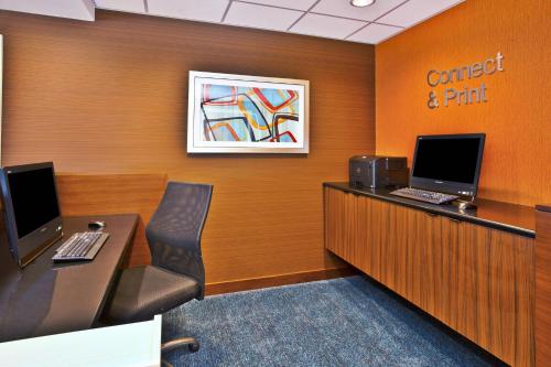 an office cubicle with a desk with two computers on it at Fairfield Inn & Suites by Marriott Madison West/Middleton in Madison
