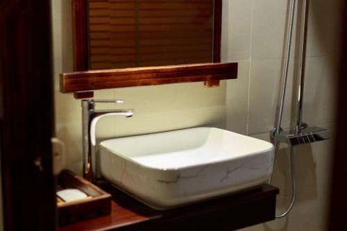 a white sink in a bathroom with a mirror at De Amor House & Coffee in Sa Pa