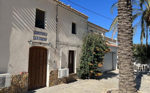 a building with a palm tree in front of it at Cortijo La Cueva in Arboleas