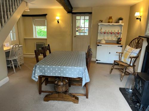 een eetkamer met een tafel en een keuken bij Wensleydale Stone Cottage in Hunton