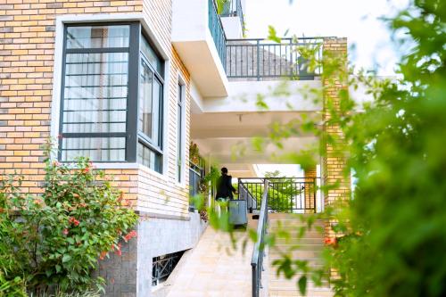 a woman walking down the stairs of a house at MAYA Residences Rwanda in Kigali