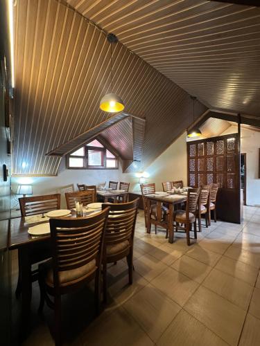 comedor con mesas y sillas de madera en Wingait Inn - Hotel Near The Mall Road, en Shimla