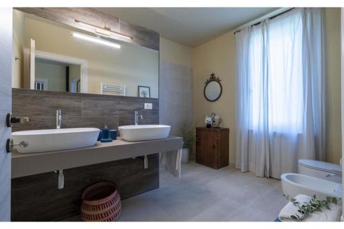 La salle de bains est pourvue de 2 lavabos et d'un grand miroir. dans l'établissement Villa Zara, à Palaia