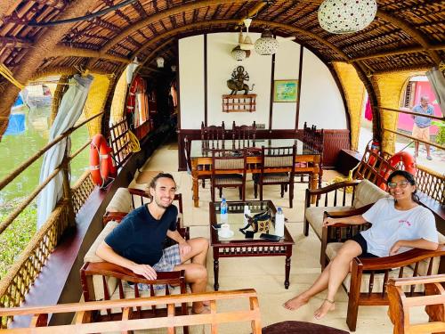 dos personas sentadas en un restaurante de trenes en Thara's Houseboat, en Alleppey