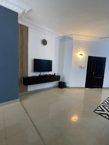 sala de estar con TV de pantalla plana en la pared en Villa 2 chambres salon, en Abomey-Calavi