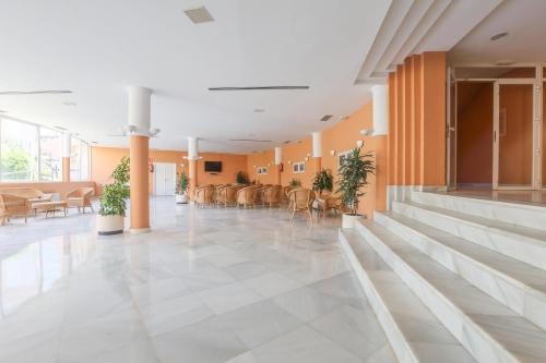 an empty lobby with chairs and tables in a building at Las Americas in Islantilla