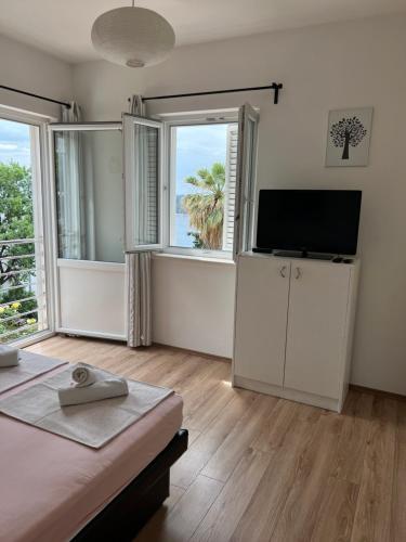 a bedroom with a bed and a flat screen tv at Apartments Romano in Dubrovnik