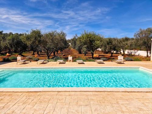 a swimming pool in a yard with trees at Trulli Tramontana - private pool in Ostuni