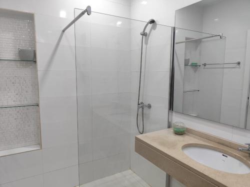 a bathroom with a sink and a glass shower at Isa Charme Home in Praia