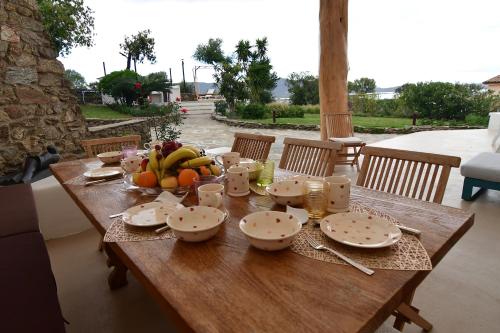 a wooden table with a bowl of fruit on it at Amoreddu in San Teodoro