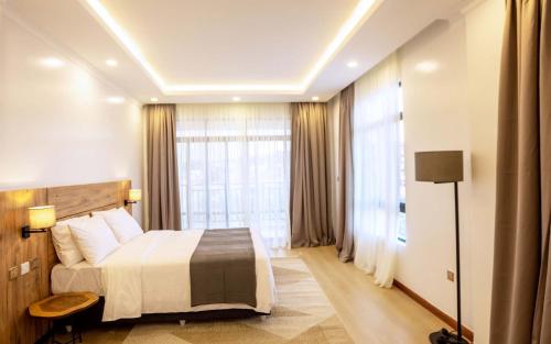 a hotel room with a bed and a large window at MAYA Residences Rwanda in Kigali