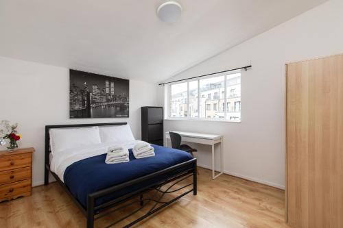 1 dormitorio con cama, escritorio y ventana en Double Room in Maida Vale, en Londres