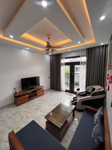 uma sala de estar com um sofá e uma televisão em Eco House em Ilha de Cát Bà