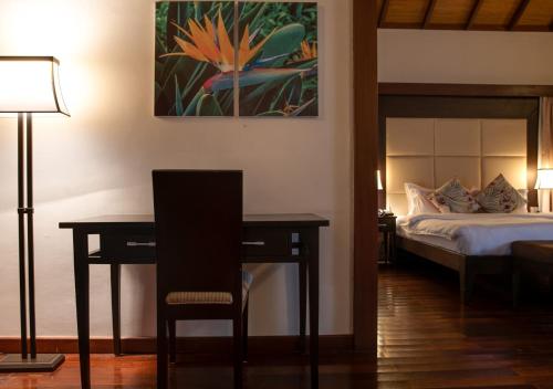 a bedroom with a bed and a desk and a table at Lakowe Lakes Hotel, Golf and Country Estate by NEWMARK in Lagos