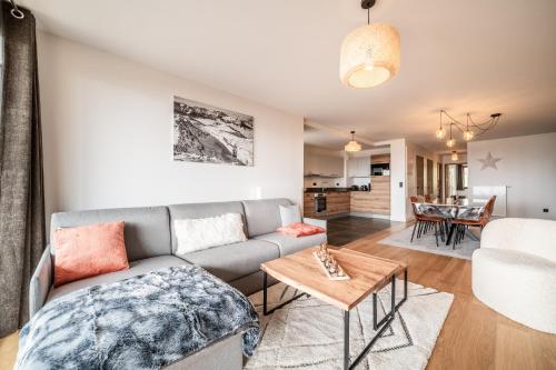 un salon avec un canapé et une table dans l'établissement Apartment Epicea Alpe d'Huez - by EMERALD STAY, à Huez