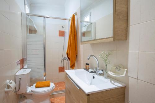 a bathroom with a sink and a toilet and a shower at Villa Dimitris Apartments & Bungalows by Imagine Lefkada in Lefkada Town