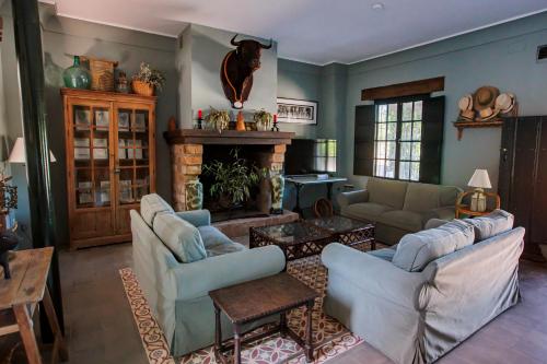 a living room with couches and a fireplace at Habitaciones El Rocio in El Rocío