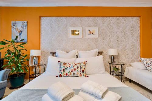a bedroom with a large white bed with orange walls at Cosy apartment in Queluz
