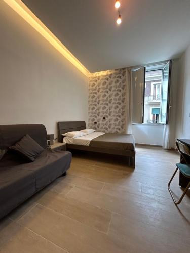a bedroom with two beds and a large window at Binario 14 Piazza Garibaldi in Naples