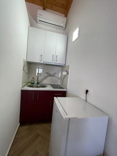 a kitchen with a white refrigerator and a sink at Panorama Sea View Apartments in Vlorë
