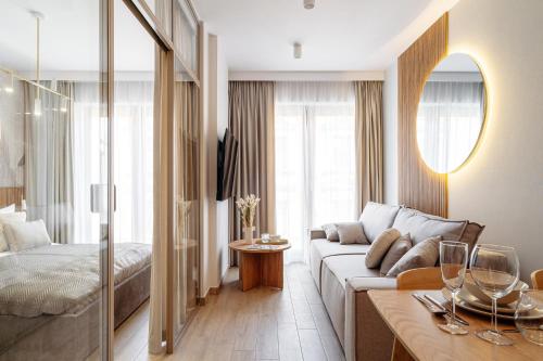 a living room with a couch and a bed at Muse - LoftAffair Spa Collection in Kraków