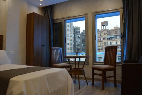 tourist hotels cairo downtown في القاهرة: غرفة فندقية بسرير وطاولة مع كراسي
