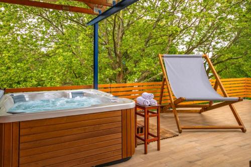 a hot tub and a chair on a deck at Sekli Panzió in Balatonlelle